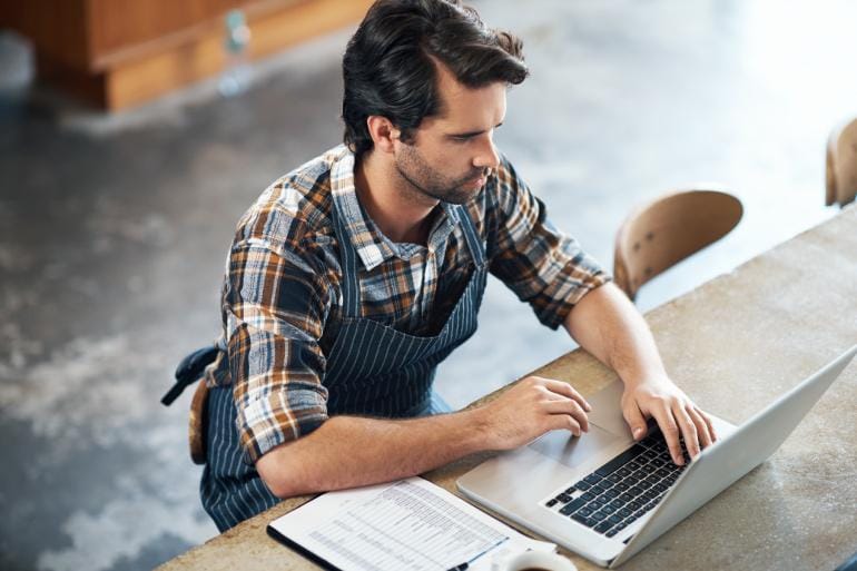 Restaurant owner creating an email marketing campaign on a laptop.