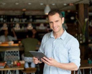 Restaurant owner using a tablet to implement marketing strategies for restaurants and grow the business