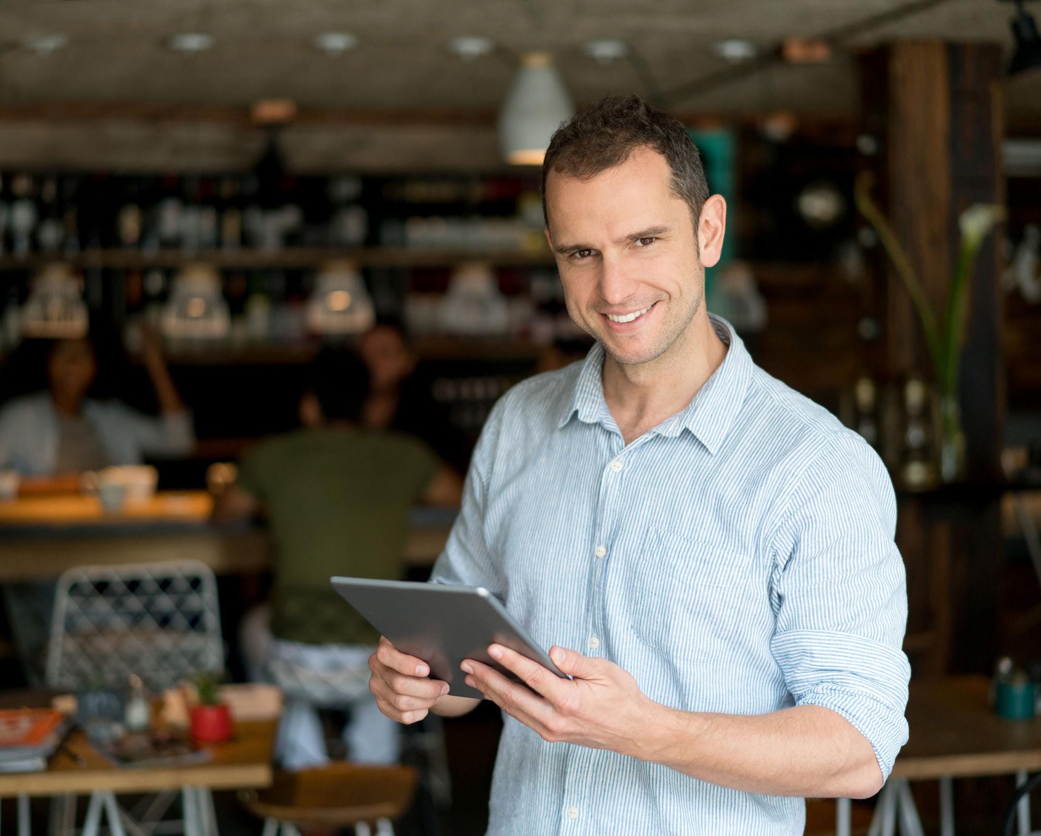 Restaurant owner using a tablet to implement marketing strategies for restaurants and grow the business